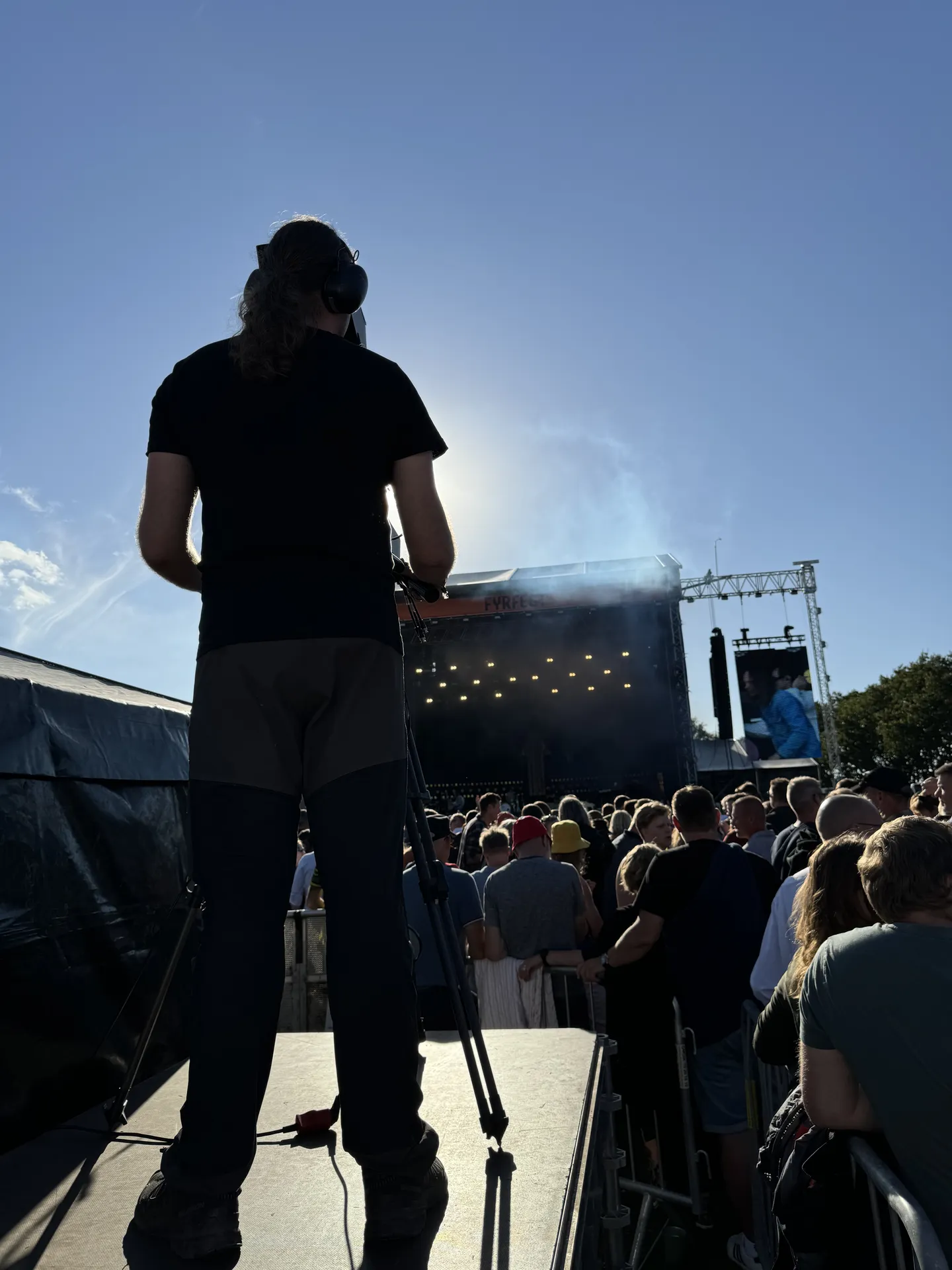 Kameraoperatør filmer publikum og scenen ved et arrangement